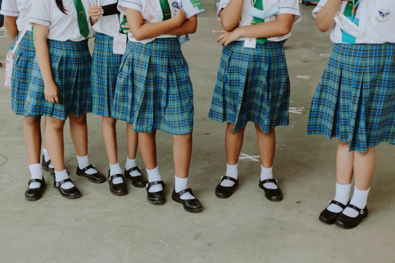 a group of young girls standing next to each other, trending on unsplash, quito school, extra short blue plaid skirt, wearing green, white uniform, shoes