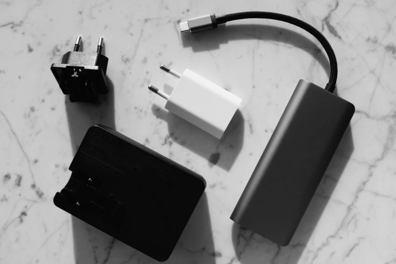 a charger sitting on top of a marble counter top, a black and white photo, unsplash, square shapes, computer components, various posed, homemade