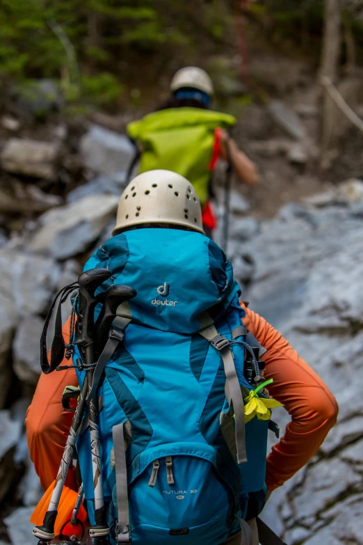 a couple of people with backpacks on a trail, a picture, by Daren Bader, figuration libre, helmet view, chartreuse and orange and cyan, up close shot, thumbnail