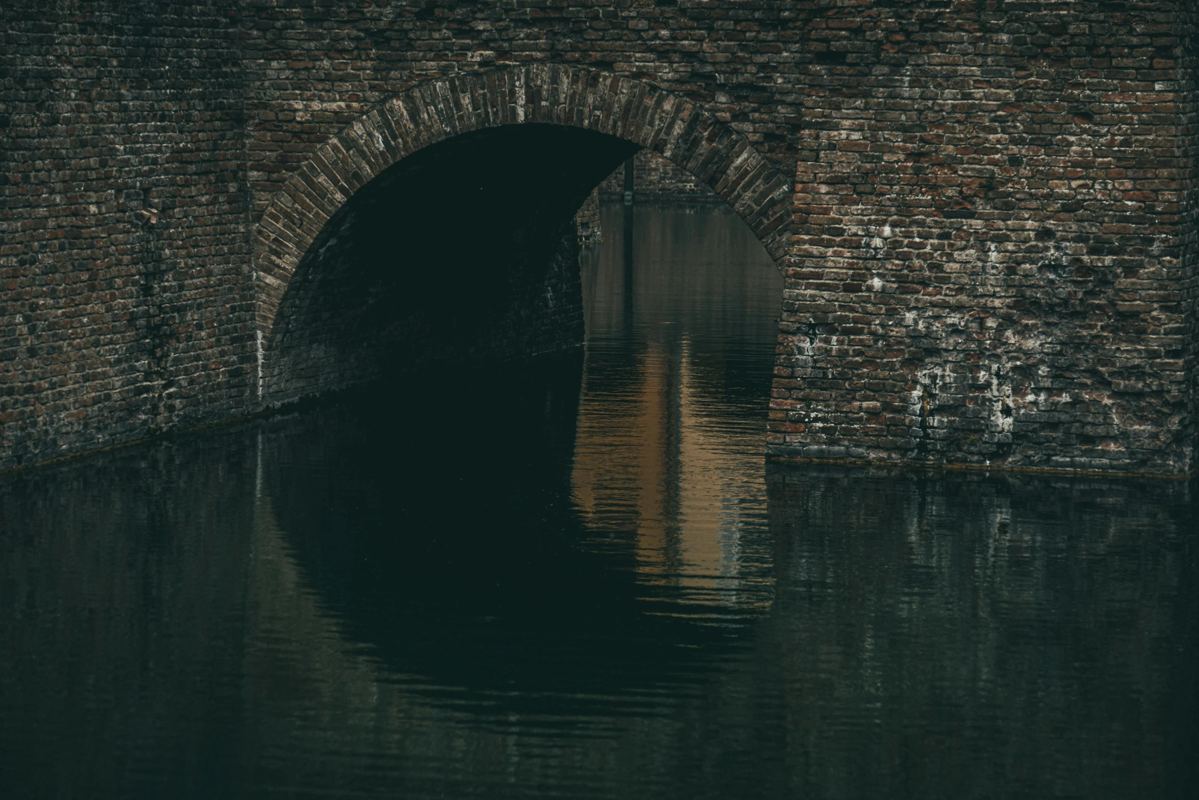 a brick bridge over a body of water, inspired by Elsa Bleda, pexels contest winner, tonalism, sewer pipe entrance, utrecht, archs, a mysterious