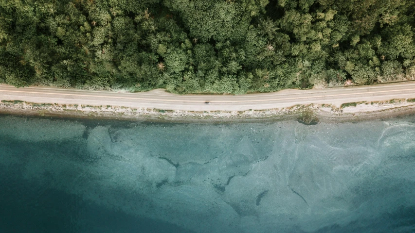 an aerial view of a road next to a body of water, unsplash contest winner, ignant, ultrawide lens”, fiona staples, highly rendered