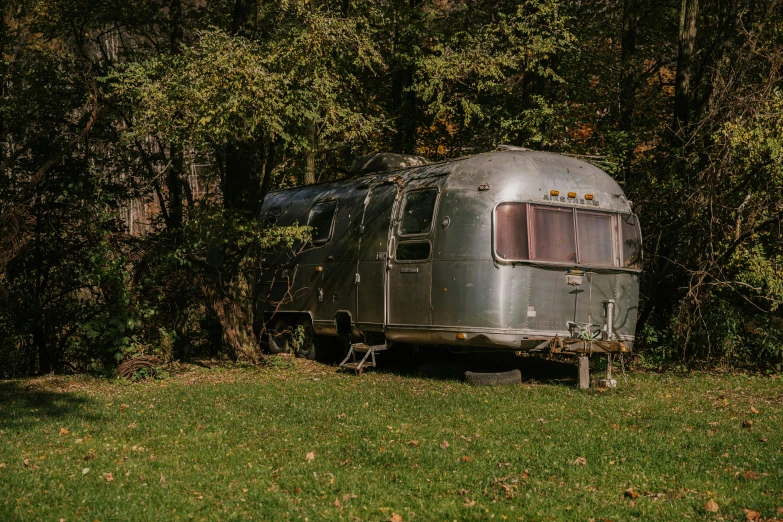 a trailer that is sitting in the grass, a portrait, unsplash, 7 0 s photo, gray, fan favorite, high - resolution photograph