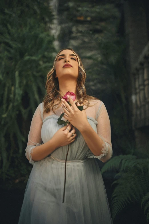 a woman in a white dress holding a pink rose, an album cover, inspired by Elsa Bleda, pexels contest winner, renaissance, alluring plus sized model, woman in a dark forest, young woman looking up, zelda