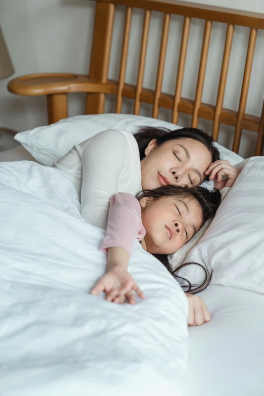 a couple of women laying on top of a bed, pexels contest winner, daughter, singapore, profile image, square