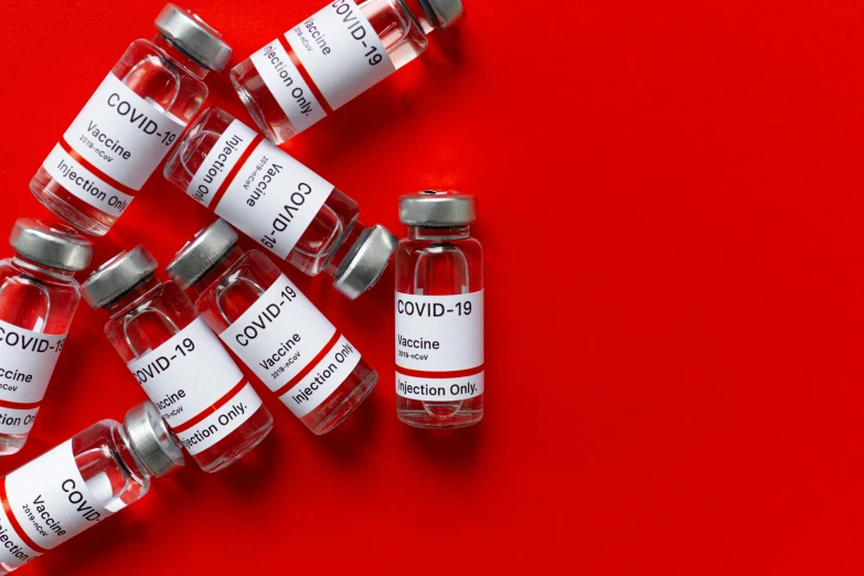 a bunch of vials sitting on top of a red surface, a picture, by Jeanna bauck, shutterstock, medical labels, covid, 1024x1024, syringe