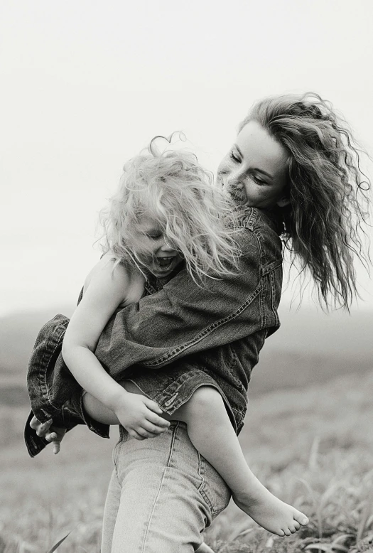 a woman carrying a little girl in a field, a black and white photo, pexels contest winner, messy hair bedhead, denim, skye meaker, a still of a happy