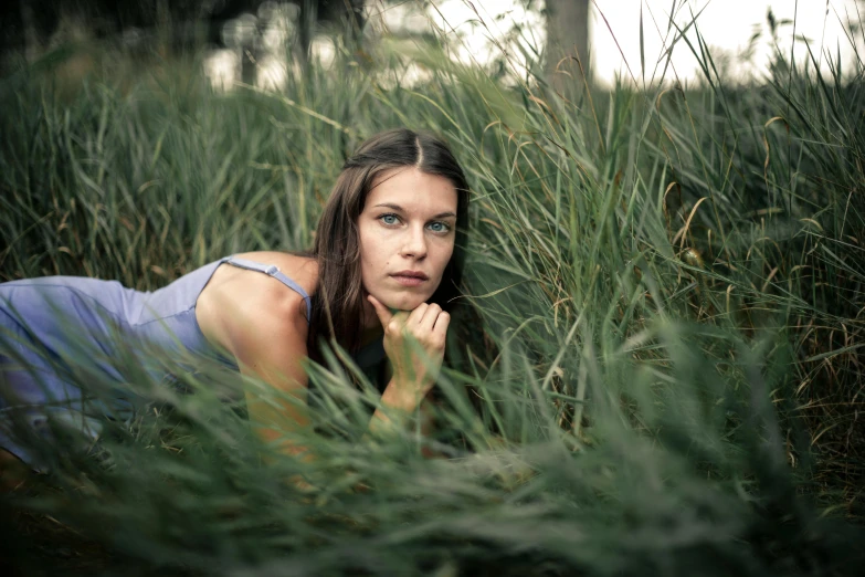 a woman laying in a field of tall grass, a picture, unsplash, renaissance, portrait image, dafne keen, 3 5 mm slide, medium format