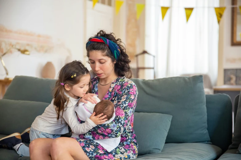 a woman sitting on a couch holding a little girl, pexels, 3 - piece, milk, seraphine, holding each other