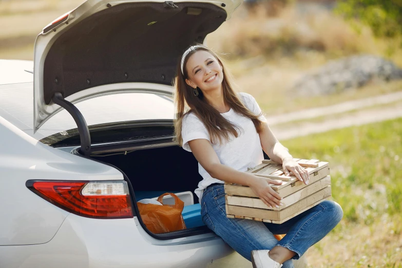 a woman sitting in the trunk of a car with a box of pizza, a picture, shutterstock, square, nature photo, lachlan bailey, 15081959 21121991 01012000 4k