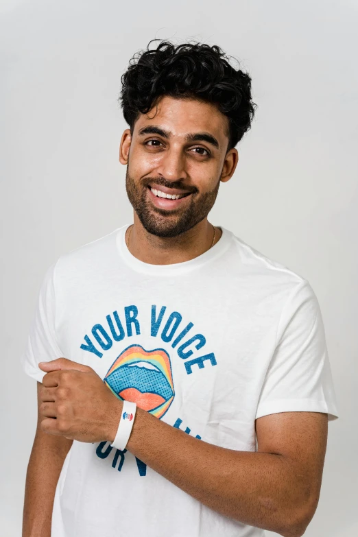 a man in a white t - shirt smiles at the camera, inspired by Ismail Gulgee, a portrait of rahul kohli, subreddit / r / whale, hand over mouth, productphoto