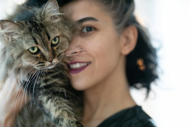 a woman holding a cat in her arms, a photo, by Julia Pishtar, pexels contest winner, androgynous face, mixed animal, tufty whiskers, the cheshire cat