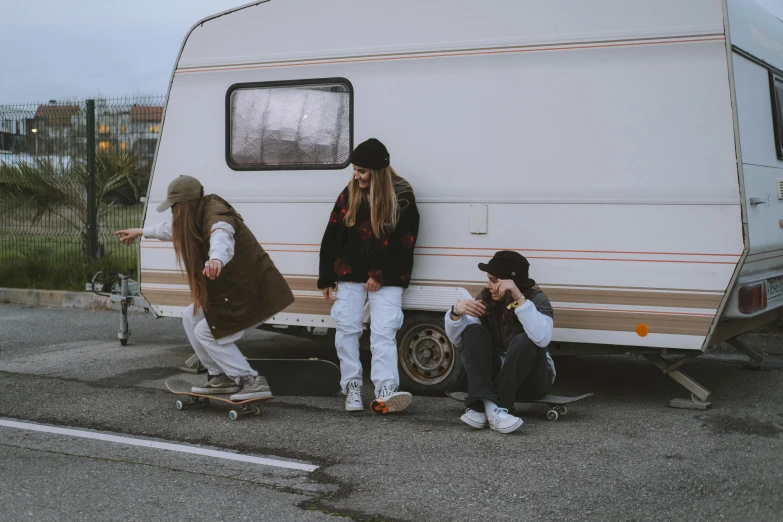 a couple of people that are sitting on a skateboard, next to an rv, woman in streetwear, 15081959 21121991 01012000 4k, travellers