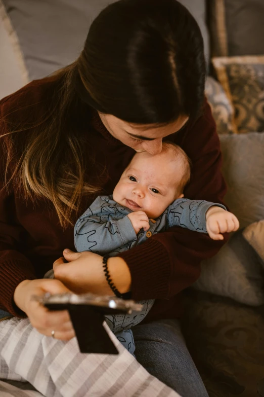 a woman sitting on a couch holding a baby, pexels contest winner, happening, hugging each other, manuka, medium close up portrait, drinking