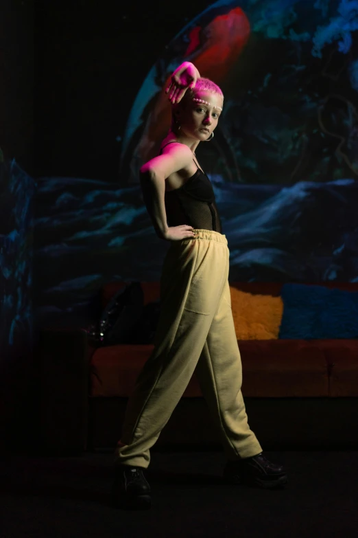 a woman walking across a stage next to a couch, inspired by Nan Goldin, unsplash, holography, portrait of kim petras, yellow lighting from right, on a mannequin. studio lighting, sassy pose