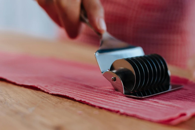 a close up of a person cutting food with a knife, coated pleats, striped, photograph taken in 2 0 2 0, high quality product image”