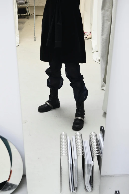 a man taking a picture of himself in a mirror, by Nina Hamnett, neo-dada, wearing tall combat boots, yeezy collection, photograph credit: ap, coated pleats