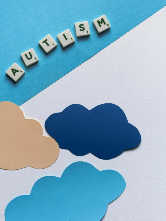 the word autism spelled in wooden letters on a blue and white background, a child's drawing, by Arabella Rankin, trending on pexels, aestheticism, cumulus cloud tattoos, high angle close up shot, idealised, mario clouds