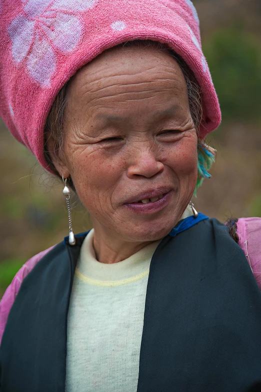 a close up of a person wearing a pink hat, flickr, cloisonnism, chinese village, portrait of a female druid, taken in the late 2010s, cleft chin