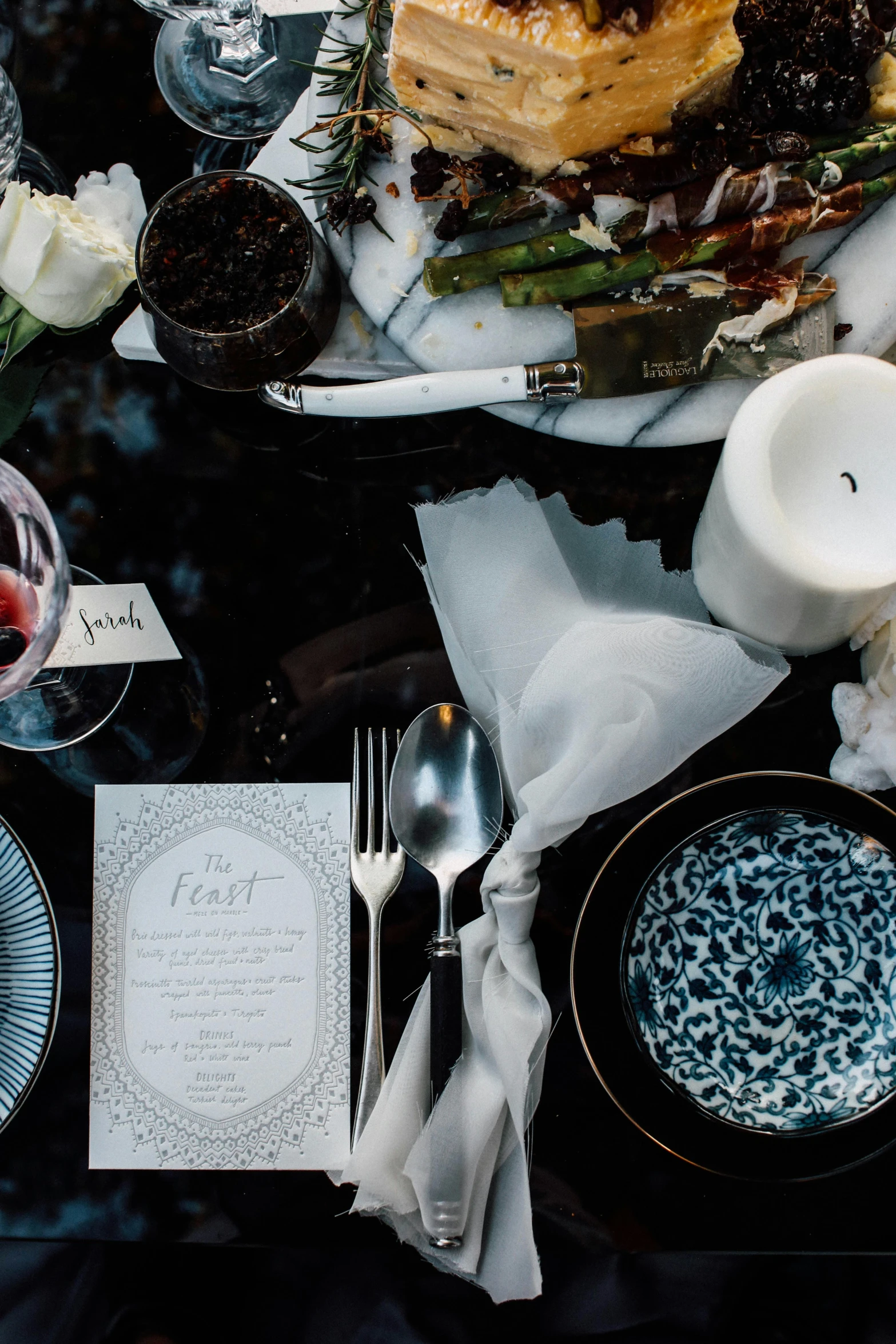 a close up of a plate of food on a table, renaissance, black and blue color scheme, bride of frankenstein, moody muted colors, ivory and black marble