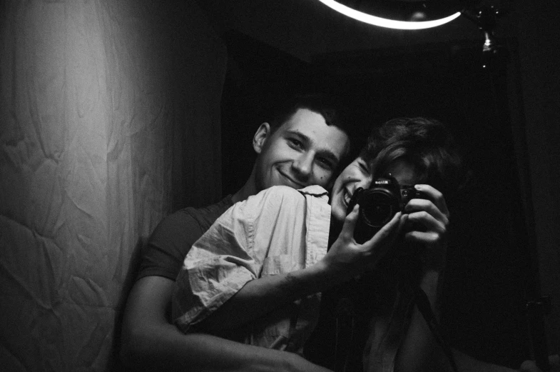 a man and a woman taking a picture in a mirror, a black and white photo, tumblr, hugs, anton semonov, camera flash, smiling couple