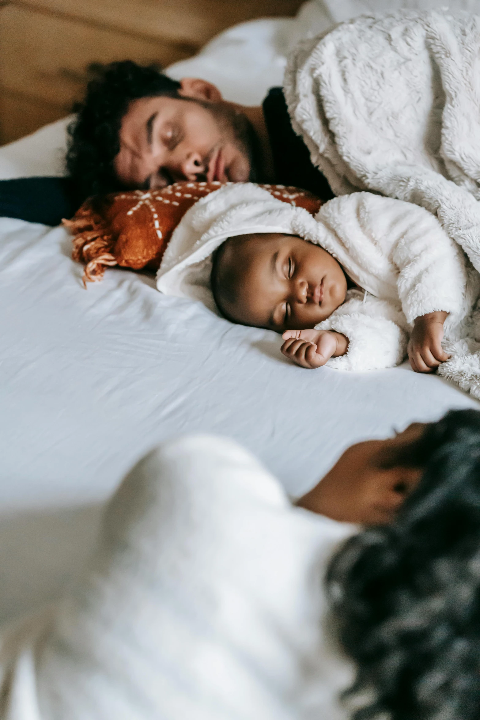 a man laying on top of a bed next to a baby, pexels contest winner, renaissance, varying ethnicities, 3 - piece, soft and warm, sleepers