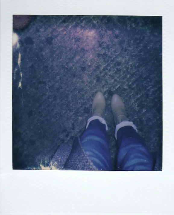 a polaroid picture of someone's feet on the ground, jeans and boots, night outside, walking together, muted pastels