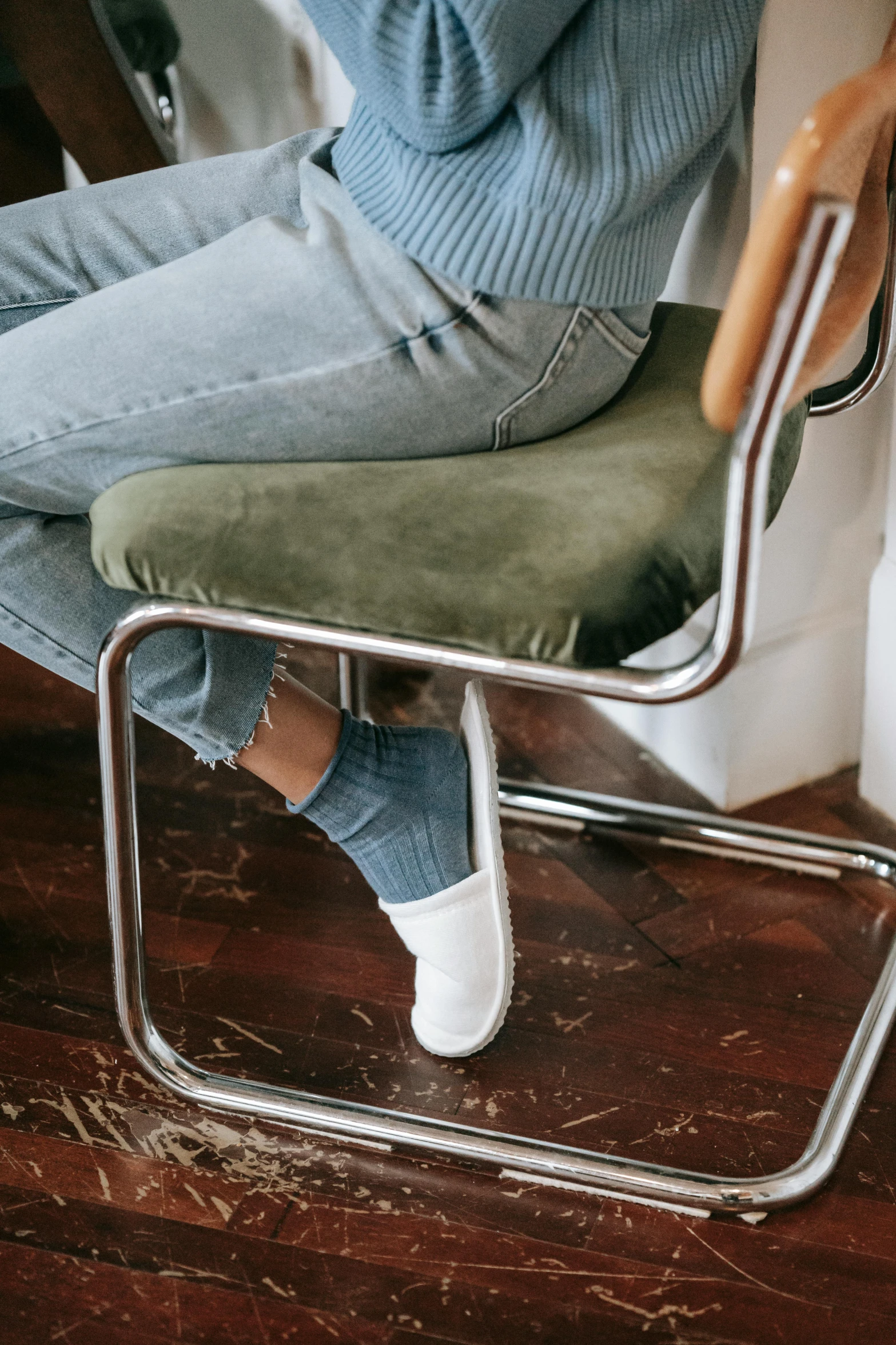 a woman sitting on a chair talking on a cell phone, wearing white sneakers, green corduroy pants, sustainable materials, rounded corners