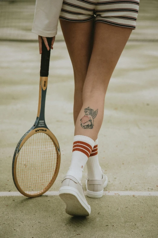 a woman holding a tennis racquet on a tennis court, a tattoo, by Jessie Alexandra Dick, trending on pexels, overknee socks, in style of norman rockwell, ink on skin, rhinoceros playing badminton