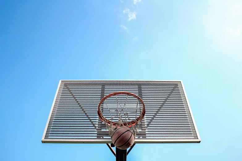 a basketball hoop with a basketball going through it, an album cover, by Jan Rustem, unsplash, clear blue skies, viewed from the ground, shot on sony a 7 iii, sport game