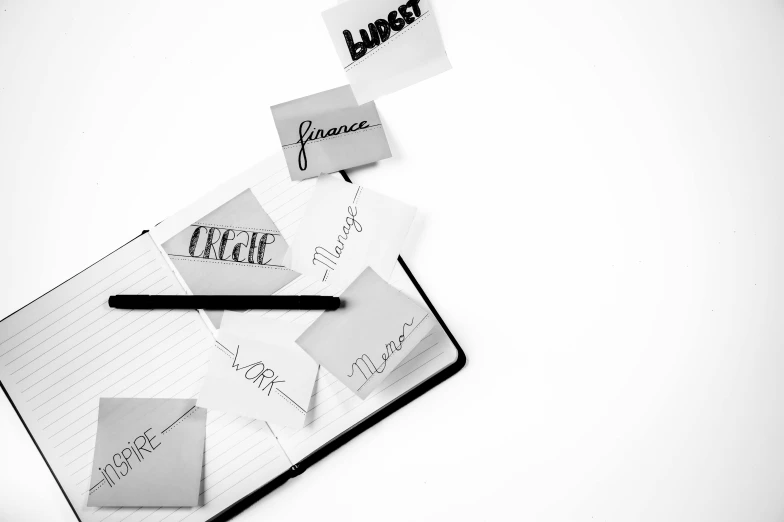 a pen sitting on top of a notebook covered in post it notes, a black and white photo, by Karl Buesgen, trending on pexels, letterism, vogue journal cover, black color on white background, french bande dessinée, lance