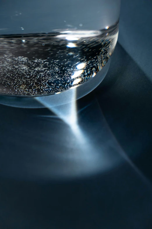 a glass bowl sitting on top of a table, by Doug Ohlson, holography, detailed swirling water tornado, microscopic view, alessio albi, close - up photograph