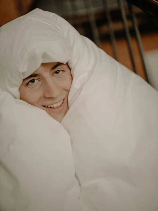 a close up of a person laying in a bed, he is smiling, freezing, white hijab, ☁🌪🌙👩🏾