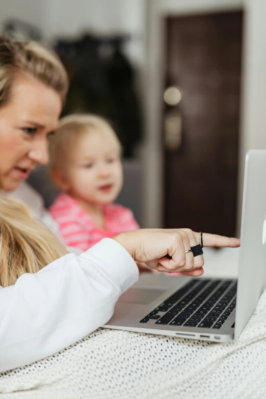 a woman and a child sitting in front of a laptop, zoomed in, mtg card trading, curated collections, white