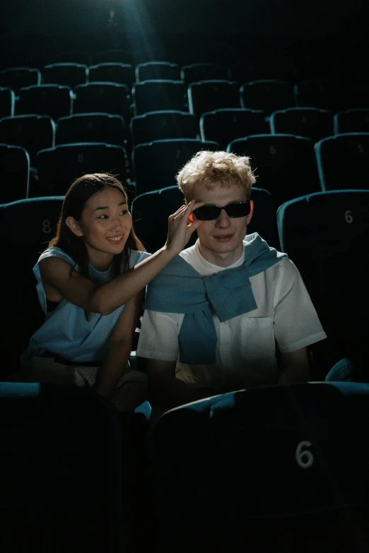 a couple of people sitting in a movie theater, yung lean, wearing blue sunglasses, [ theatrical ], cinematic luts