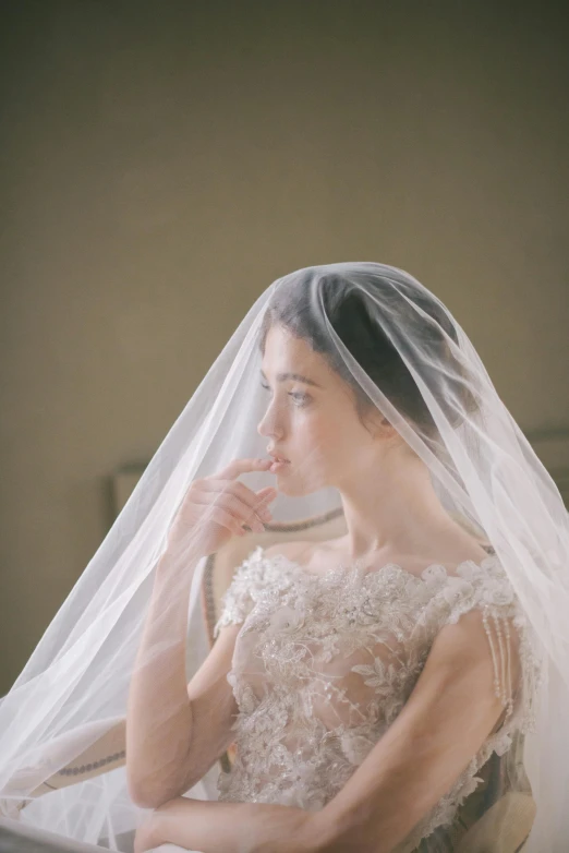 a woman sitting in a chair with a veil over her head, pexels contest winner, renaissance, song hye - kyo, wedding dress, hand over mouth, portrait of alexandra daddario