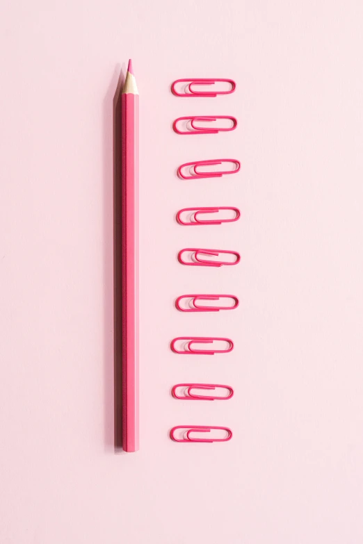 a pencil and paper clips on a pink background, trending on pexels, very tall and slender, stacked image, measurements, high resolution print :1 red