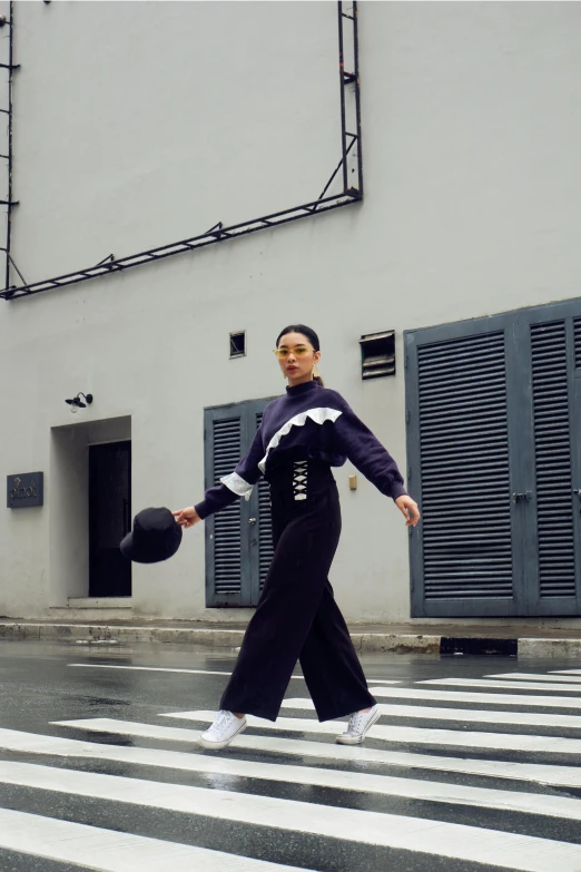 a woman walking across a crosswalk in the rain, an album cover, inspired by Gao Cen, happening, wearing a purple sweatsuit, wearing dark maritime clothing, classic dancer striking a pose, in style of lam manh