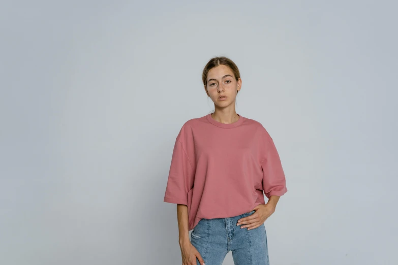 a woman standing with her hands in her pockets, trending on pexels, hyperrealism, pink shirt, demna gvasalia, muted colors. ue 5, cropped wide sleeve