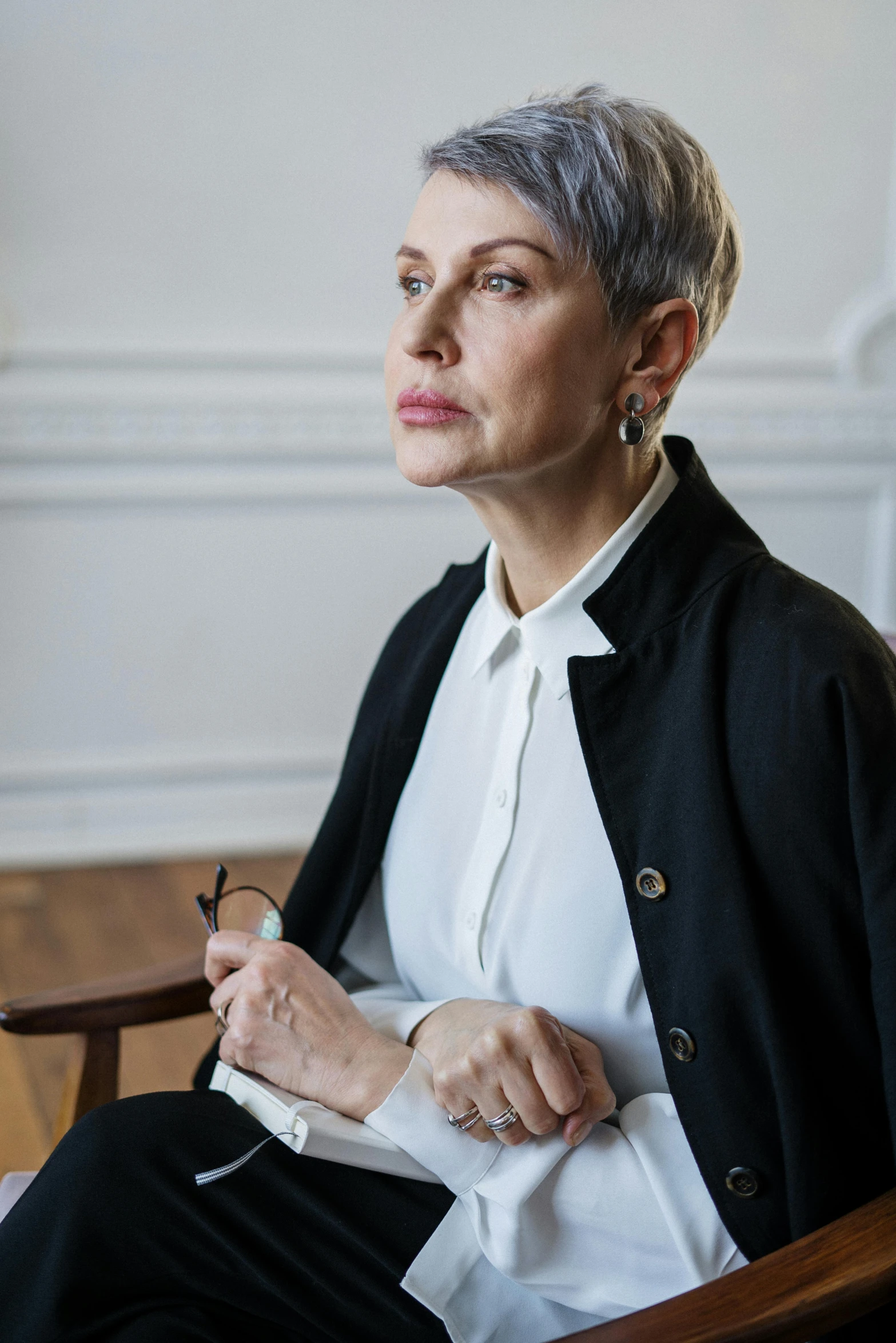 a woman sitting in a chair with a pen in her hand, a portrait, inspired by Marie-Gabrielle Capet, trending on unsplash, short platinum hair tomboy, laura letinsky and steve mccurry, madonna genderbend elegant, neri oxman
