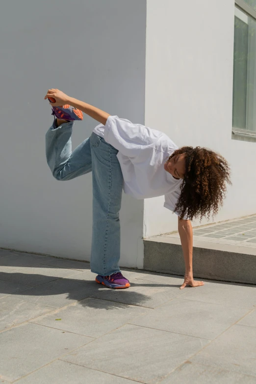 a woman is doing a trick on a skateboard, by Nina Hamnett, arabesque, issey miyake, jeans and t shirt, nathalie emmanuel, promo image