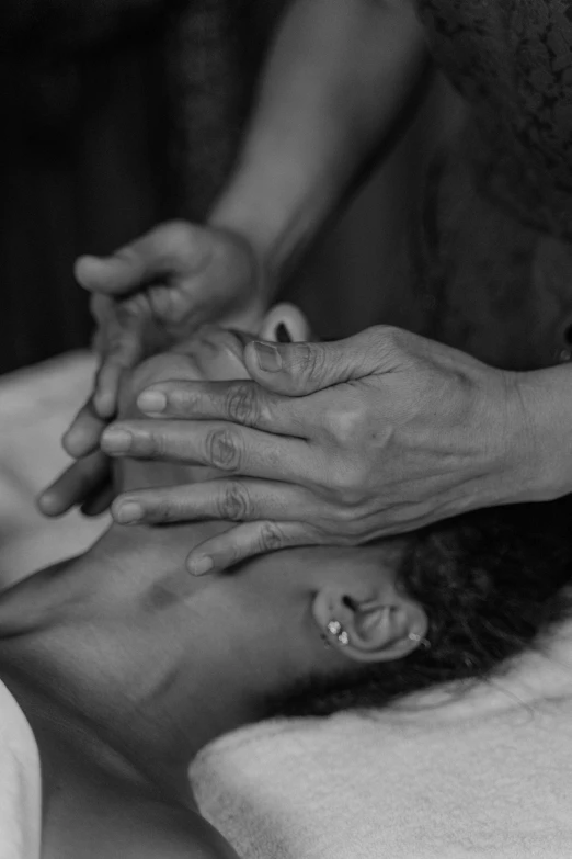 a black and white photo of a woman getting a head massage, by Nathalie Rattner, pexels, process art, maternal, blessing hands, image apothecary, childhood