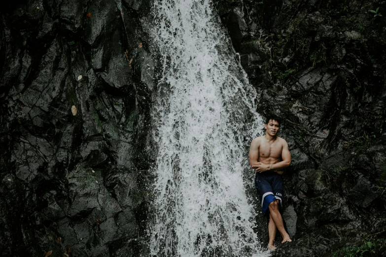 a man standing in front of a waterfall, by Alejandro Obregón, pexels contest winner, mid-shot of a hunky, jayison devadas, sasai ukon masanao, background image