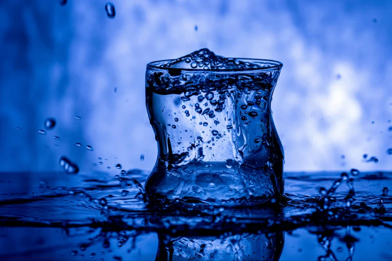 a glass filled with water sitting on top of a table, a picture, blue ice, thumbnail, water running down the walls, water armor