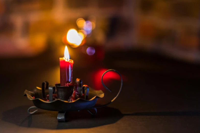 a lit candle sitting on top of a metal bowl, by Daniel Lieske, pexels contest winner, crimson themed, vignette tilt-shift, small fire, lights