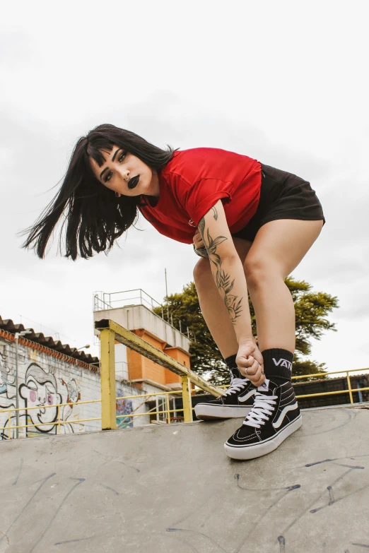 a woman riding a skateboard up the side of a ramp, an album cover, pexels contest winner, girl with black hair, in sao paulo, threatening pose, wearing red converse shoes