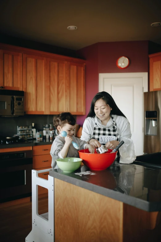 a woman and child in a kitchen preparing food, by Winona Nelson, pexels, asian descent, dwell, seattle, high quality photo