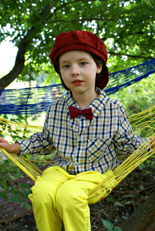 a little boy that is sitting in a hammock, a portrait, inspired by Norman Rockwell, flickr, wearing red and yellow clothes, wearing a french beret, bow tie, official screenshot