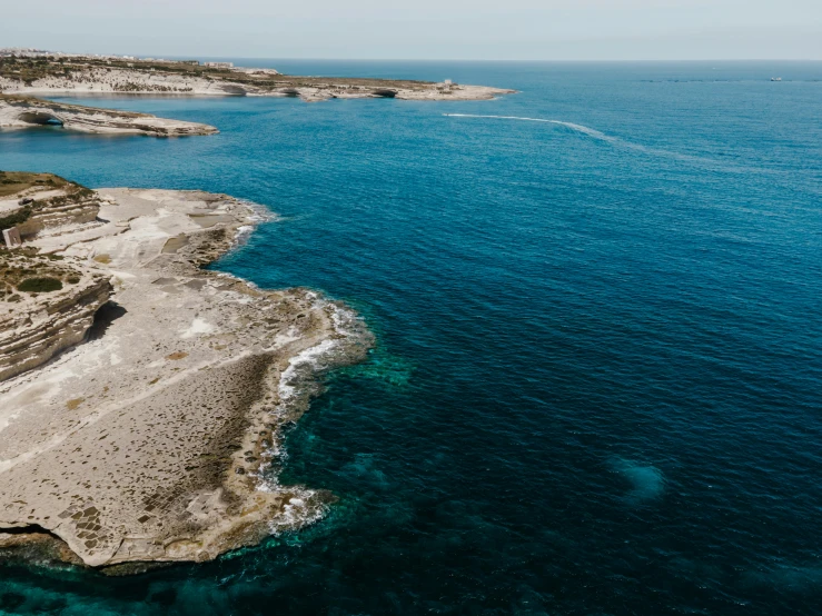 a large body of water next to a cliff, pexels contest winner, les nabis, apulia, aerial footage, islands on horizon, conde nast traveler photo