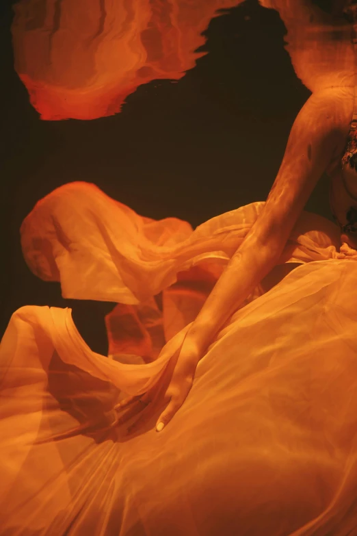 an image of a woman in an orange dress, an album cover, inspired by Georges de La Tour, arabesque, flowing salmon-colored silk, showstudio, underwater view, detail
