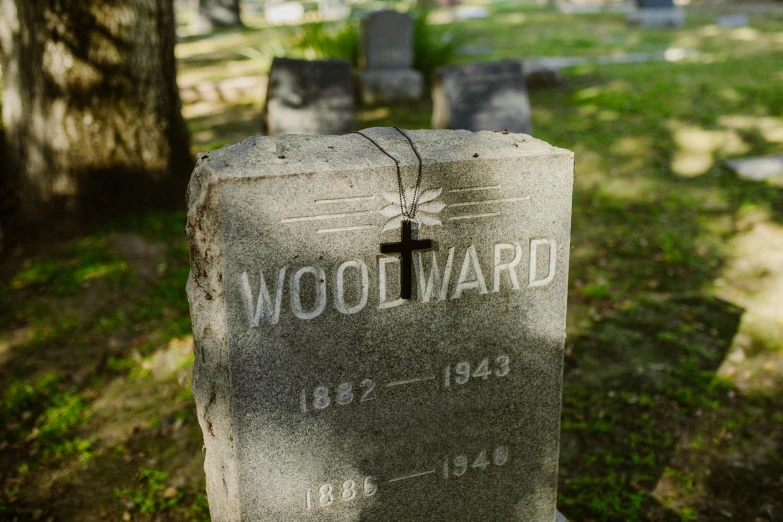 a close up of a grave with a cross on it, by William Woodward, portrait image, wooden jewerly, advertising photo, howard